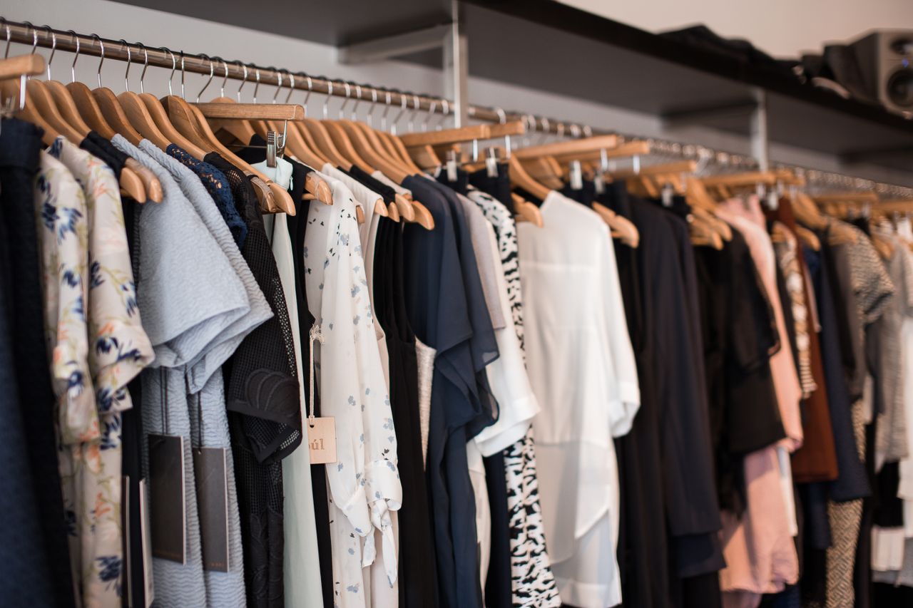 Offerings Vibrant clothing display on wooden hangers in a modern boutique setting.